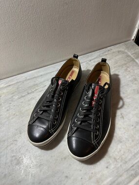 Prada Black Leather Low-Top Sneakers with White Sole and Red Tongue Accent